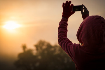 Fototapeta premium woman hiker taking photo with smart phone at mountain peak