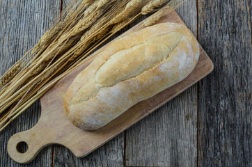 Bread and Wheat on a Rustic Cutting Board