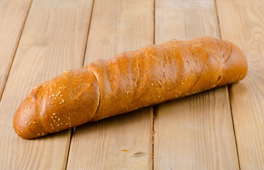 Fresh baked traditional white bread on a wooden background.