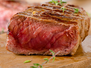 Grilled  steak on    cutting board .