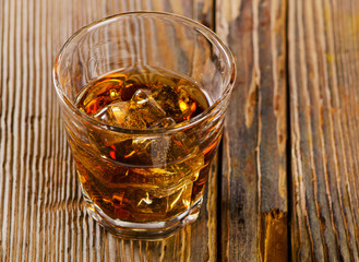 Glass of whiskey on  wooden background
