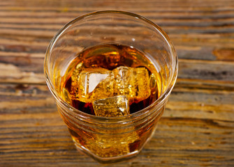 Glass of whiskey on a wooden background