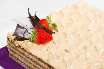 Walnut layered cake with strawberry and chocolate garnish