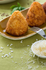 fried rice croquettes on brown plate with cheese and fork