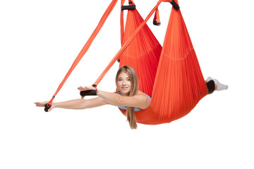 Young woman doing aerial yoga in hammock on a