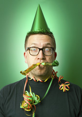 Mann mit Partyhut und zwei Papiertr&ouml;ten im Mund