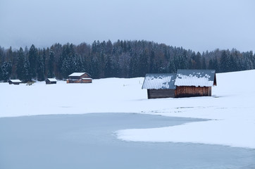 wooden hut on snowy meadow