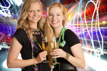 Freundinnen mit Sektgläsern vor Disco-Hintergrund