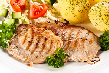 Fried steaks, boiled potatoes and vegetable salad