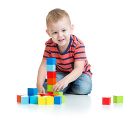 Kid playing and building tower with colorful blocks
