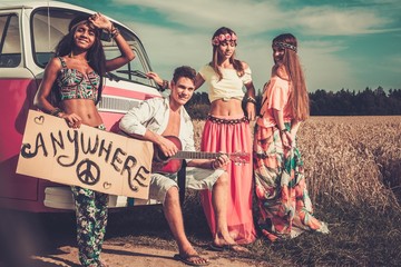 Multi-ethnic hippie hitchhikers  on a road