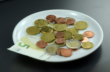 Münzen auf Teller