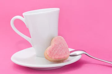 Fotobehang Koffiebar kopje koffie met petit four in hart op een roze achtergrond,