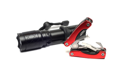 flashlight and multi tools on a white background