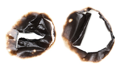 Collection of burnt holes in a piece of paper isolated on white