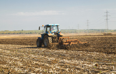 Fototapeta premium Farmer in tractor preparing land for sowing