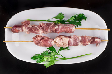 Raw skewer and vegetables on plate