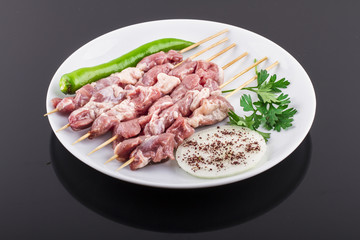 Raw skewer and vegetables on plate