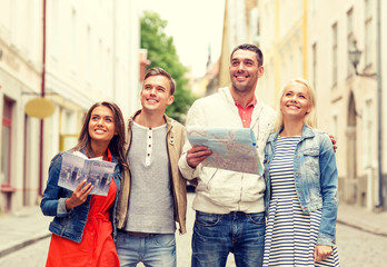 group of smiling friends with city guide and map