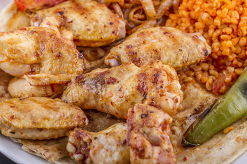 grilled chicken wings and legs on wooden plate