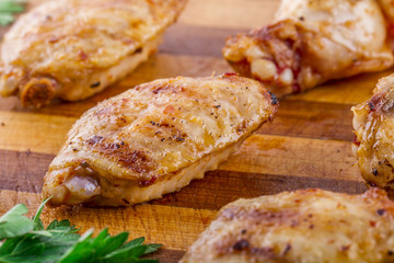 grilled chicken wings and legs on wooden plate