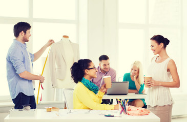 smiling fashion designers working in office