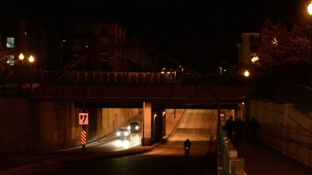 Biker riding under a bridge at night