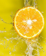 orange in water on a yellow background background