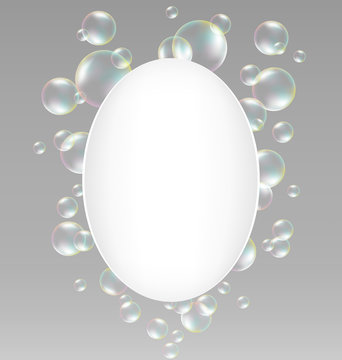 Transparent iridescent soap bubbles with white oval frame on gra