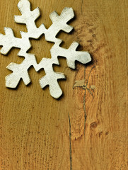 Huge white snowflake and wooden background.