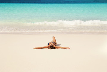 Fototapeta na wymiar Young girl lying on the beach