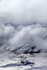 Obraz premium Top view on ski slope and hotels in mist