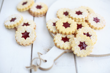 Linzer Kekse mit Himbeerkonfitüre auf einem Holztisch
