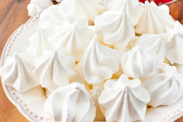 Porcelain plate full of many fluffy white meringue