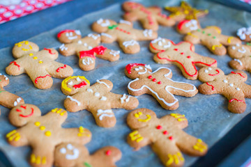 Fototapeta na wymiar Raw gingerbread men with glaze on a baking sheet
