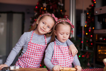 Fototapeta na wymiar Cute little girls preparing gingerbread cookies for Christmas