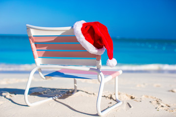 Closeup red Santa hat on chair longue at tropical beach