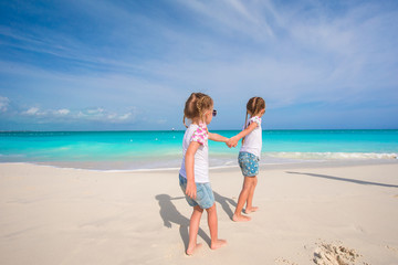 Naklejka premium Little girls having fun during tropical beach vacation