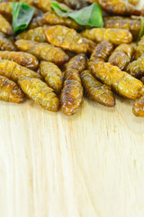 fried silk worms on cutting board for food concept