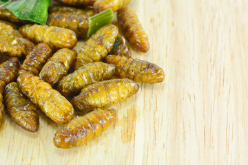 fried silk worms on cutting board for food concept