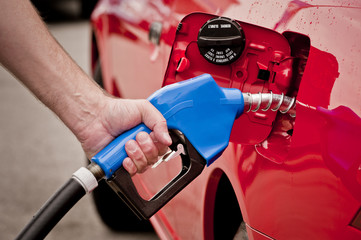 Man Using Blue Gasoline Nozzle In Red Car