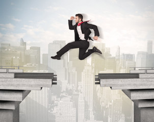 Energetic business man jumping over a bridge with gap