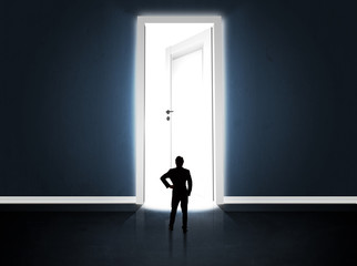 Obraz premium Business man looking at big bright opened door