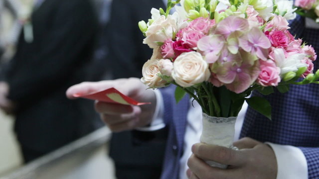 Groom with wedding bouquet and card