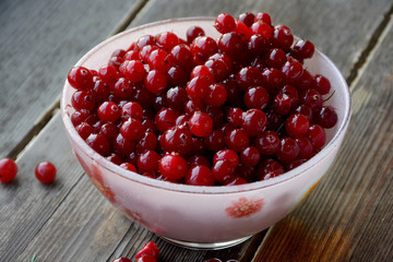 Close-up of cranberries in bowl, on wooden backround