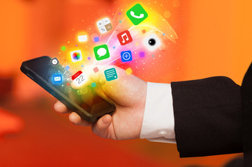 Hand holding smartphone with colorful app icons