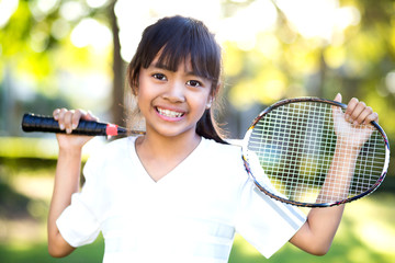 Little asian girl holding a badminton racket