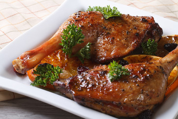 roasted duck legs on a white plate close up. horizontal
