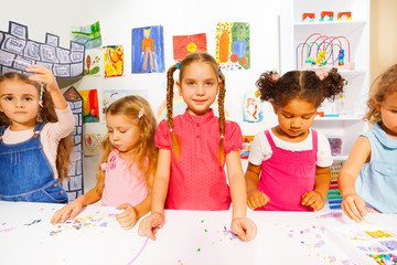 Happy little kids girls with beads in the class