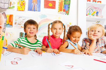 Fototapeta premium Boys and girls drawing letters in writing lesson